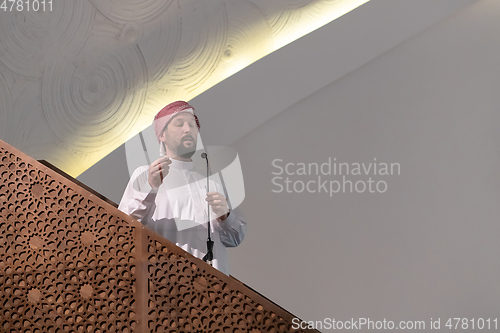 Image of Muslims young arabic Imam has a speech on friday afternoon prayer in mosque.