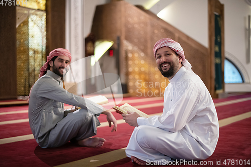 Image of two muslim people in mosque reading quran together concept of islamic education