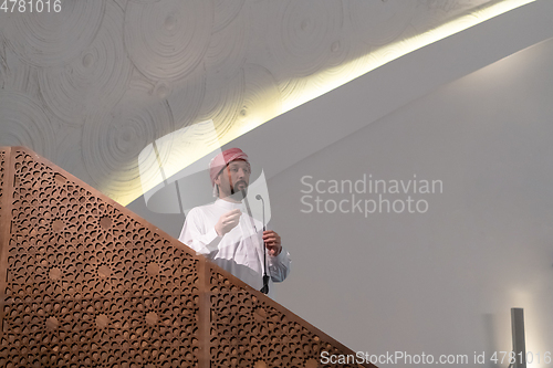 Image of Muslims young arabic Imam has a speech on friday afternoon prayer in mosque.