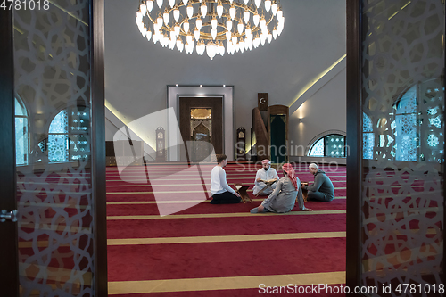 Image of muslim people in mosque reading quran together