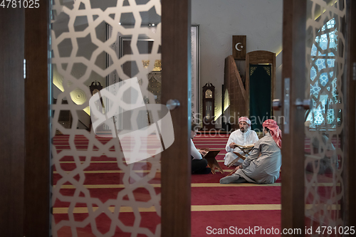 Image of muslim people in mosque reading quran together