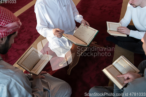 Image of muslim people in mosque reading quran together