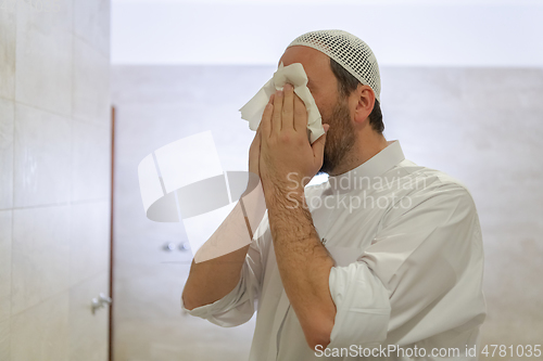 Image of a portrait of a man in abdesthana using a towel