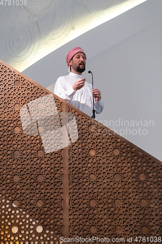 Image of Muslims young arabic Imam has a speech on friday afternoon prayer in mosque.