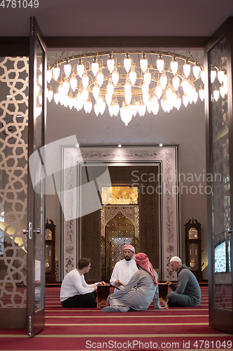 Image of muslim people in mosque reading quran together