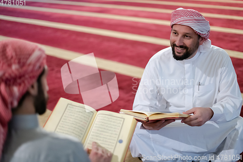 Image of two muslim people in mosque reading quran together concept of islamic education