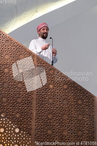 Image of Muslims young arabic Imam has a speech on friday afternoon prayer in mosque.