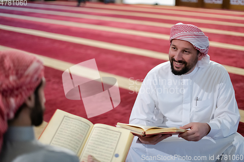 Image of two muslim people in mosque reading quran together concept of islamic education