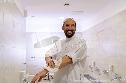 Image of a portrait of a man in abdesthana using a towel