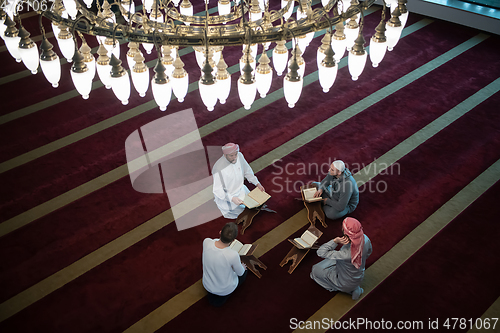 Image of muslim people in mosque reading quran together