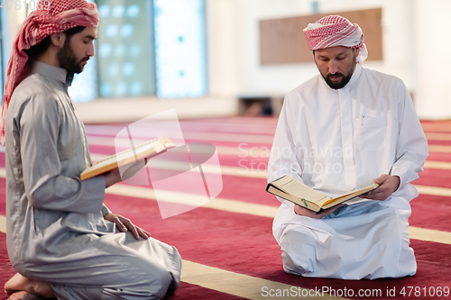 Image of two muslim people in mosque reading quran together concept of islamic education