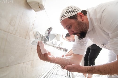 Image of a group of Muslims take ablution for prayer. Islamic religious rite