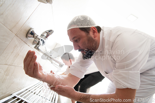 Image of a group of Muslims take ablution for prayer. Islamic religious rite