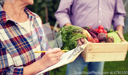 Image of senior couple with box of vegetables at farm