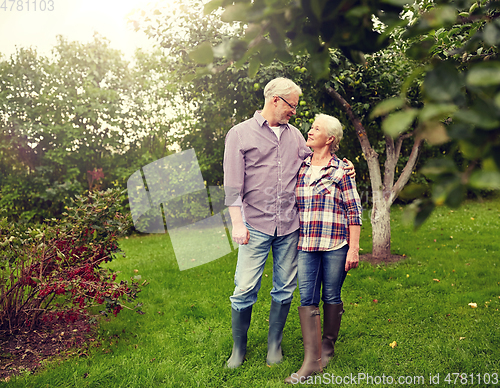 Image of happy senior couple hugging at summer garden