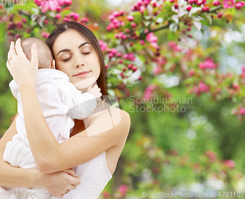Image of mother with baby over spring garden background
