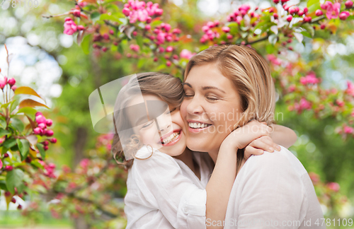 Image of happy mother and daughter hugging over garden