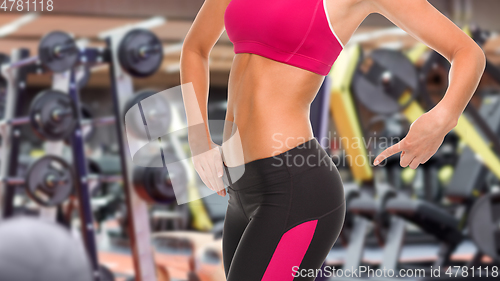 Image of close up of fit woman pointing to her buttocks