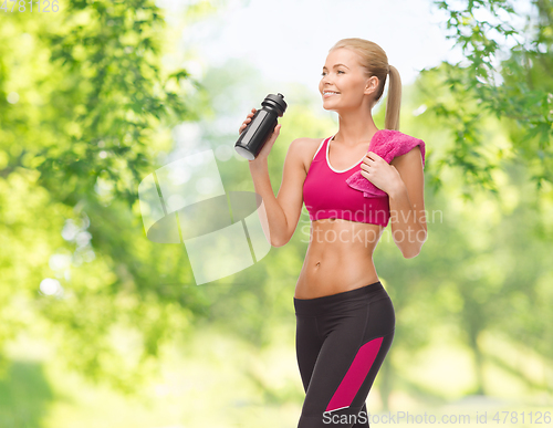 Image of sporty woman drinking water from bottle