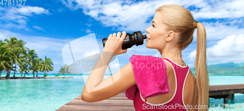 Image of happy smiling woman with sports bottle and towel