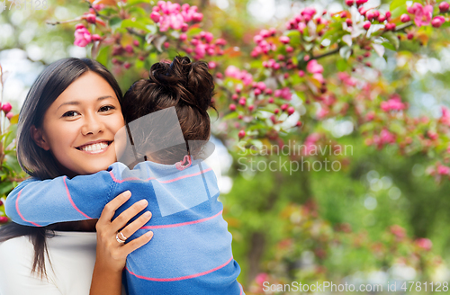 Image of happy mother and daughter hugging over garden