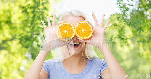 Image of happy woman having fun covering eyes with orange