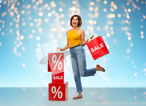 Image of happy smiling young woman with shopping bags