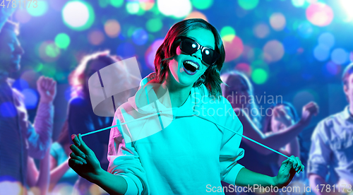 Image of woman in hoodie and sunglasses at nightclub