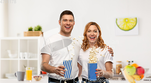 Image of happy couple in white t-shirts eating popcorn