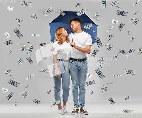 Image of happy couple with umbrella standing money rain