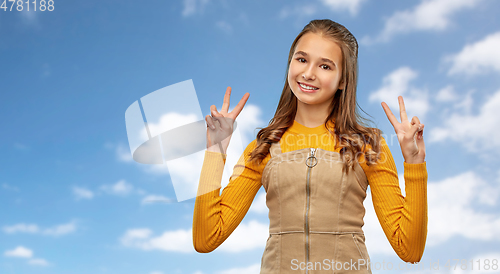 Image of smiling young teenage girl showing peace hand sign