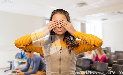 Image of student girl closing her eyes by hands at school