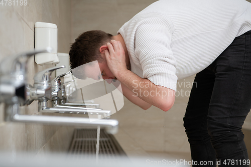 Image of A Muslim takes ablution for prayer. Islamic religious rite