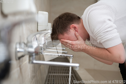 Image of A Muslim takes ablution for prayer. Islamic religious rite