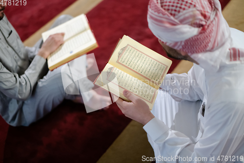 Image of two muslim people in mosque reading quran together concept of islamic education