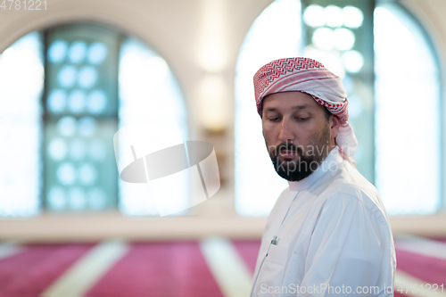 Image of a Muslim ends a prayer by turning his head to the side,.