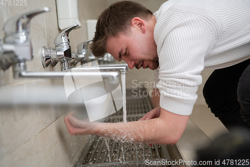 Image of A Muslim takes ablution for prayer. Islamic religious rite