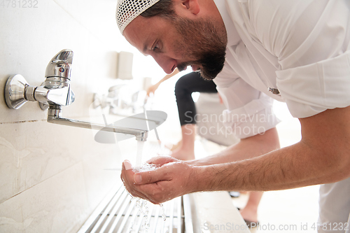 Image of a group of Muslims take ablution for prayer. Islamic religious rite