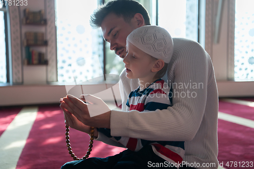 Image of muslim prayer father and son in mosque prayingtogether