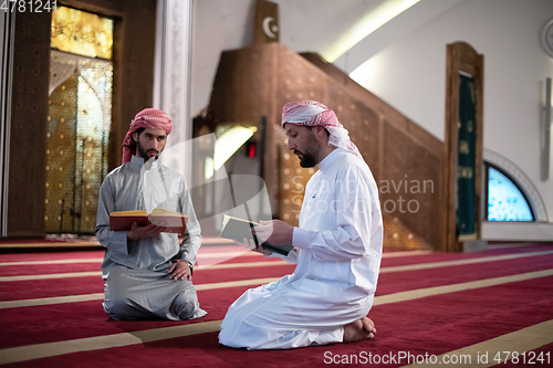 Image of two muslim people in mosque reading quran together concept of islamic education