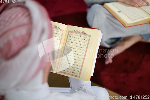 Image of two muslim people in mosque reading quran together concept of islamic education