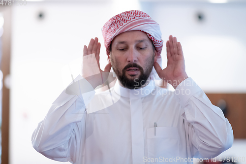 Image of a Muslim begins to offer prayer by raising his hands in the air, a calm state in prayer.