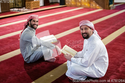 Image of two muslim people in mosque reading quran together concept of islamic education