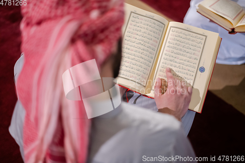 Image of two muslim people in mosque reading quran together concept of islamic education