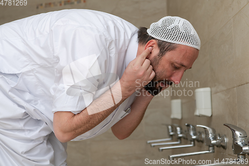 Image of A Muslim takes ablution for prayer. Islamic religious rite