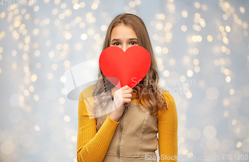 Image of smiling teenage girl hiding over red heart