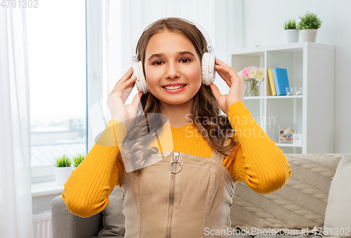 Image of teen girl in headphones listens to music at home