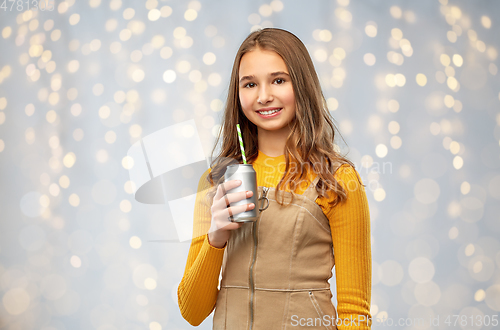 Image of happy teenage girl drinking soda from can