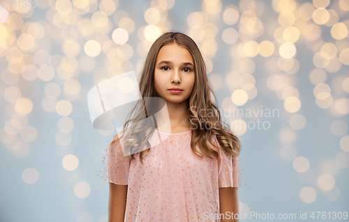 Image of teenage girl in party dress over festive lights