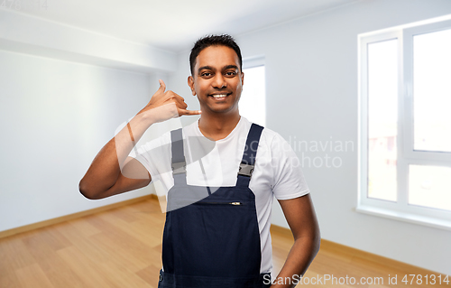 Image of builder making phone call gesture at new home